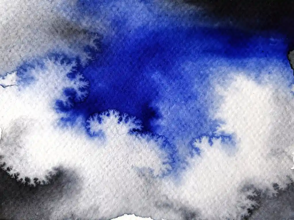 Abstracte aquarel met diepblauwe pigmenten die vervloeien in witte wolken op gestructureerd papier