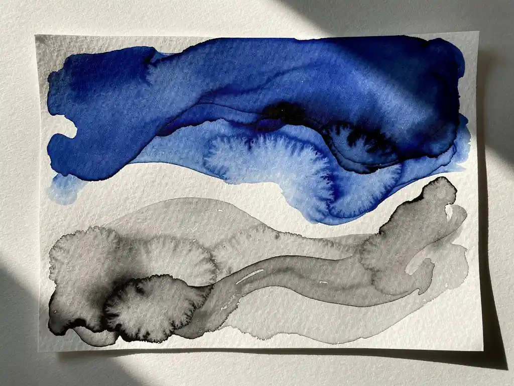Abstracte aquarel met diepblauwe verf die overvloeit in grijze wassen en witte negatieve ruimtes op getextureerd papier