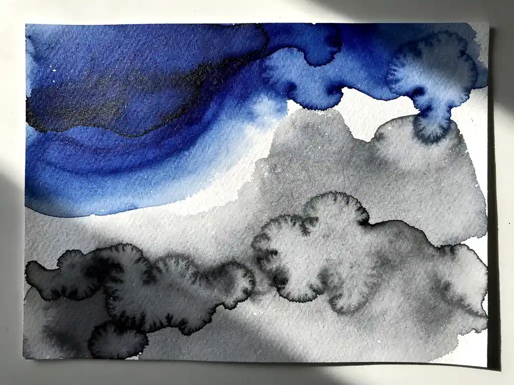 Abstracte aquarel met diepblauwe vloeistoffen die overgaan in grijze tinten en witte ruimtes op getextureerd papier