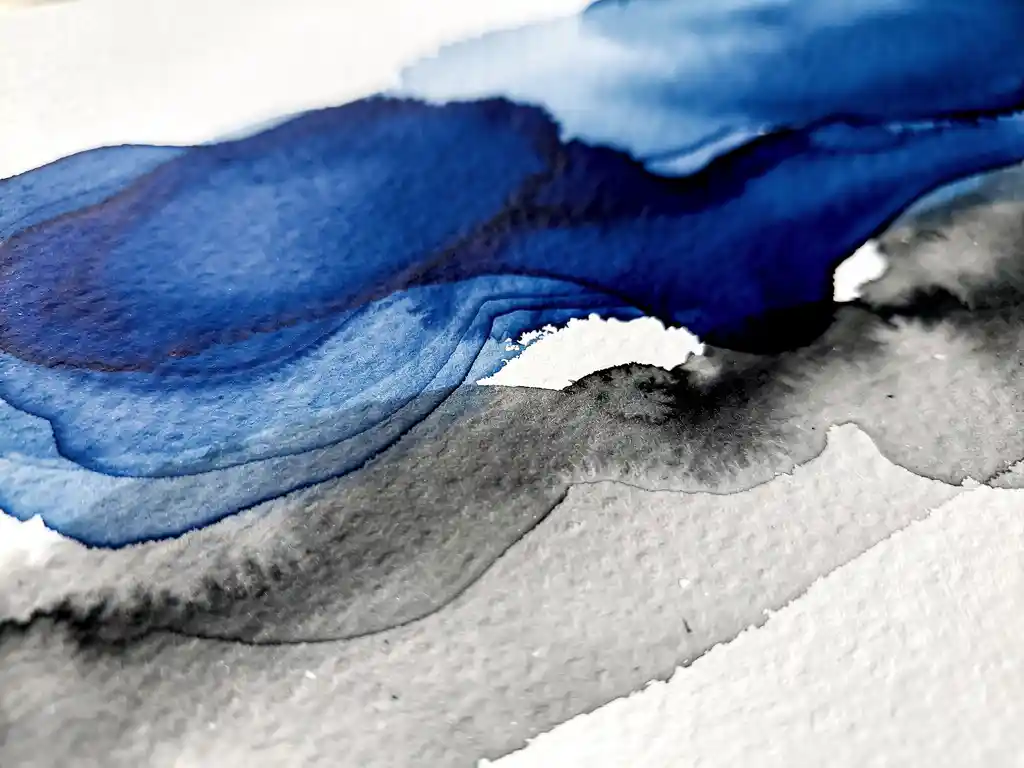 Vloeiende aquarelverf in diep koningsblauw en zachte grijstinten op getextureerd aquarelpapier met witte negatieve ruimtes