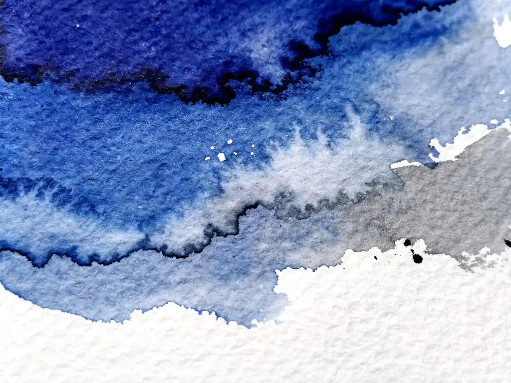 Waterverf vloeit over gestructureerd wit papier met diepblauwe en grijze tinten in abstracte gradiënten