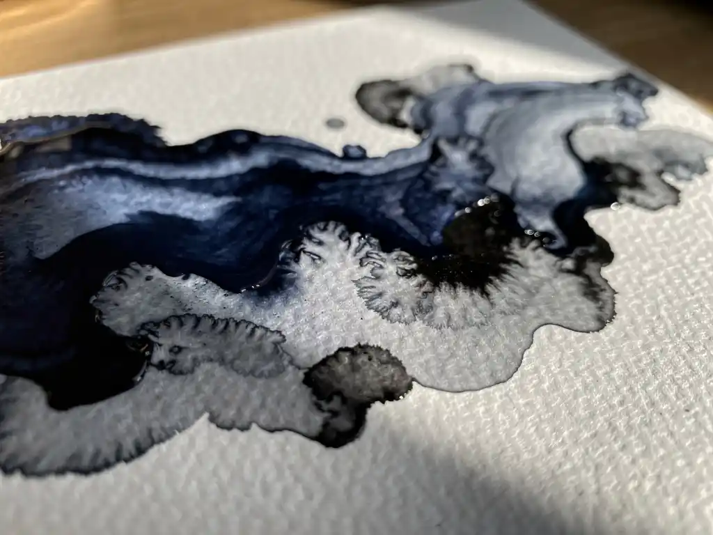 Donkerblauwe aquarelverf vloeit over getextureerd wit papier met grijze uitwassingen en zwarte accenten