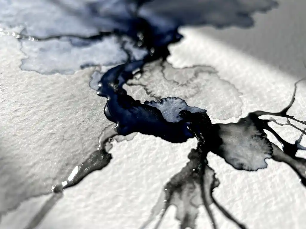 Donkerblauwe aquarelverf vloeit over nat wit papier met grijze uitwassingen en zwarte accenten in organische patronen