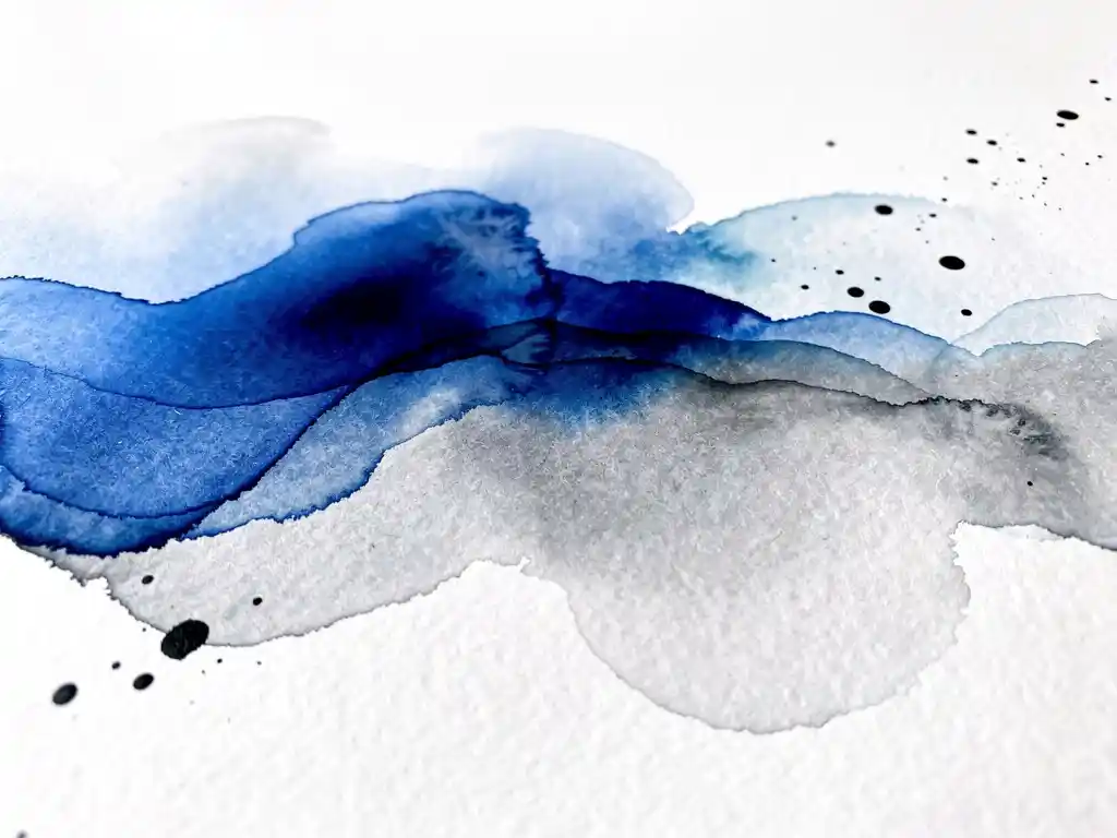 Abstracte waterverf met kobaltblauwe vloeistoffen die overgaan in grijze tinten op wit canvas met zwarte inktdruppels