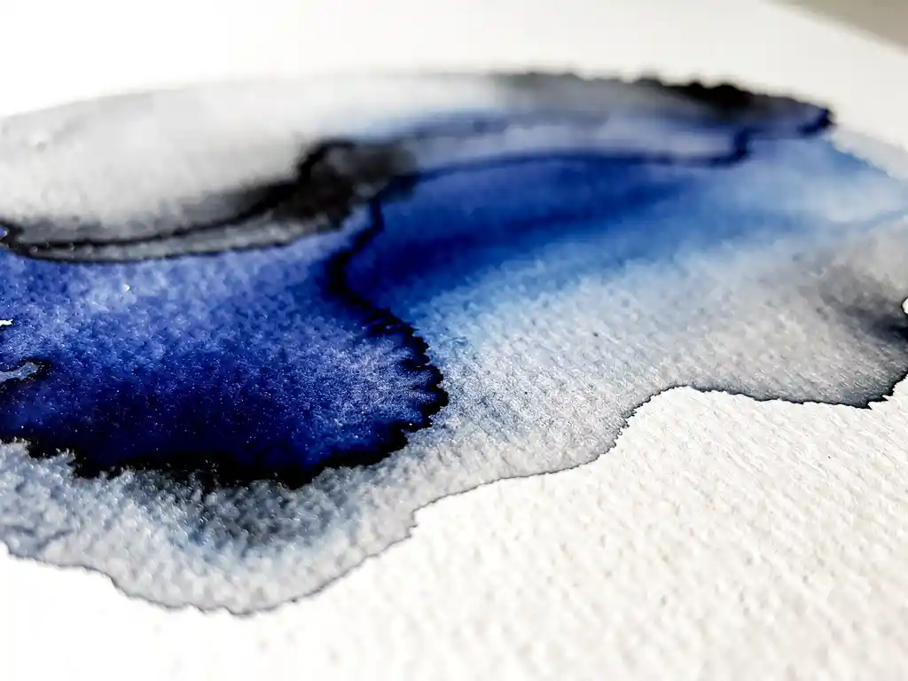 Abstracte aquarel met cobaltblauwe verfstromen die overgaan in zachte grijstinten op wit papier