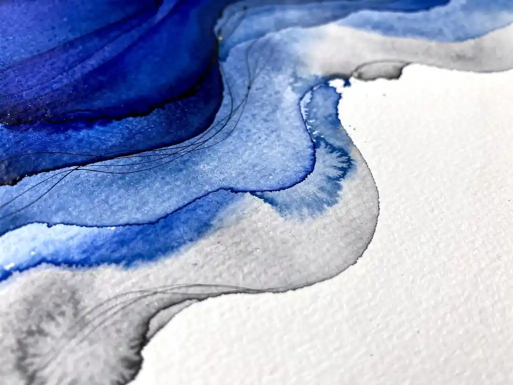 Abstracte aquarel met elektrisch blauwe verfstromen die overgaan in grijze tinten op gestructureerd papier