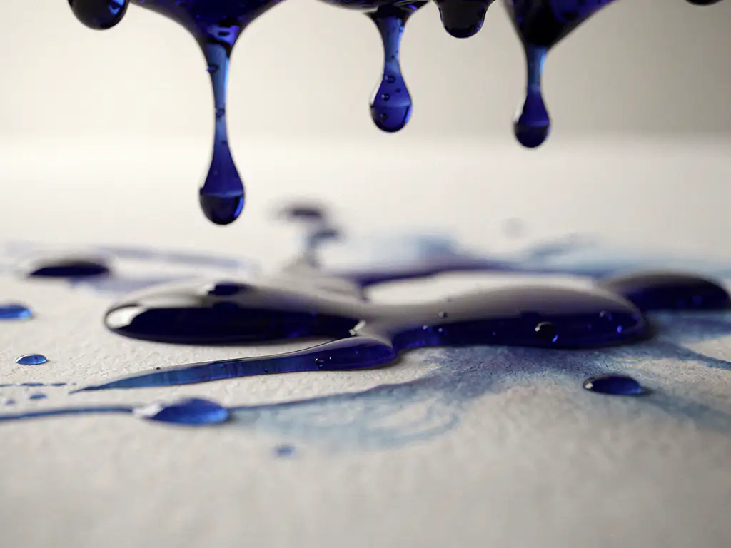Kobaltblauwe waterdruppels hangen aan onzichtbaar oppervlak en vallen op wit papier met zachte schaduwen