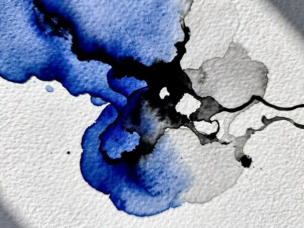Cobalt blauwe aquarelverf vloeit over getextureerd wit papier met grijze uitwassingen en zwarte accenten