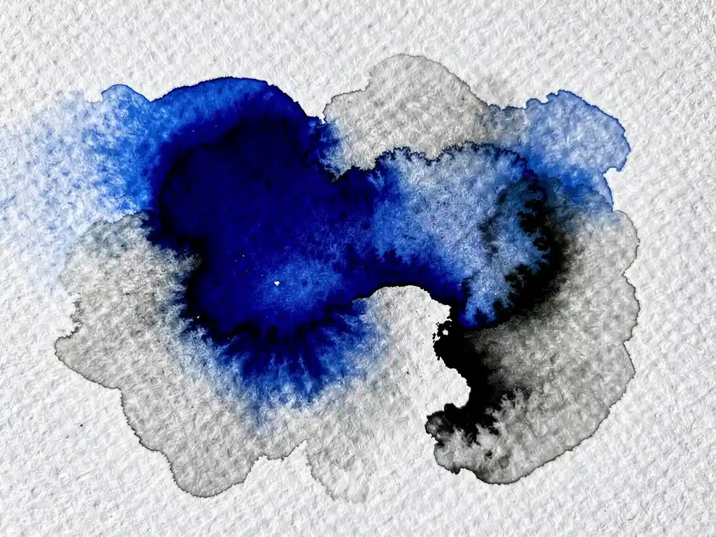 Waterverf pigmenten in kobaltblauw en grijs vloeien samen op wit textuurgepapier met natuurlijke kleurmenging
