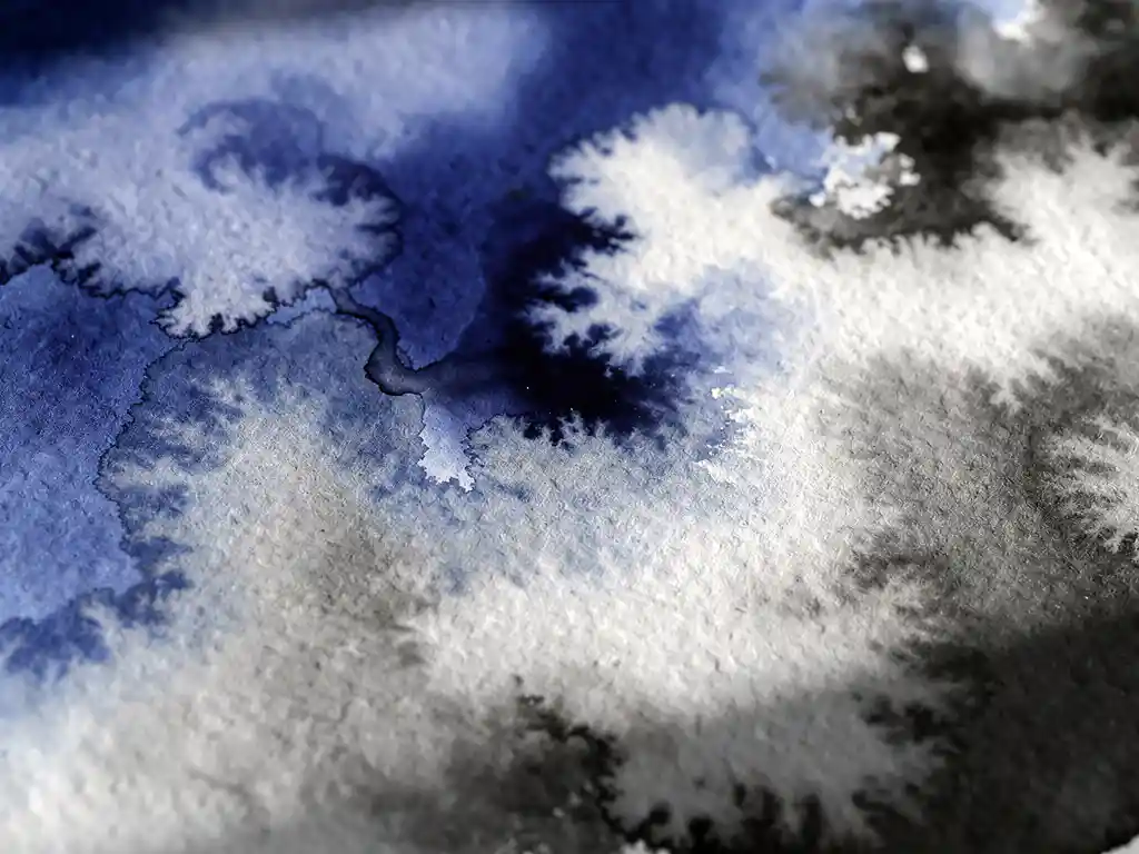Vloeiende aquarelpigmenten in diepblauw en grijstinten mengen op getextureerd papier met organische wolkachtige vormen
